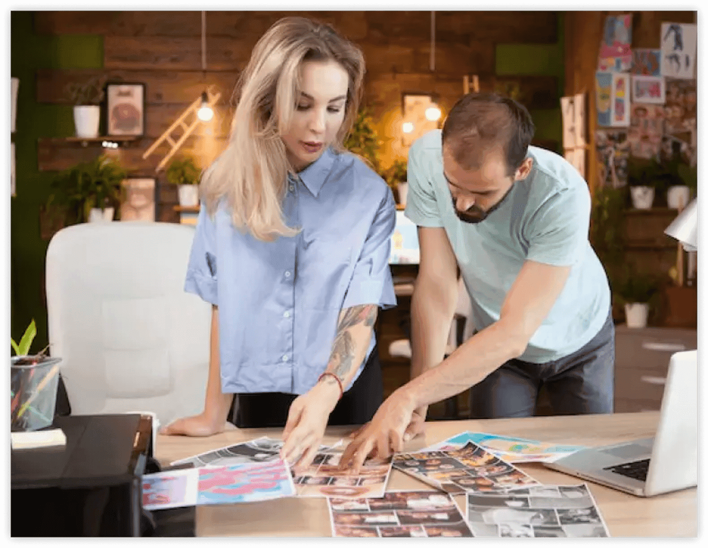 Two people are looking at pictures placed on a table